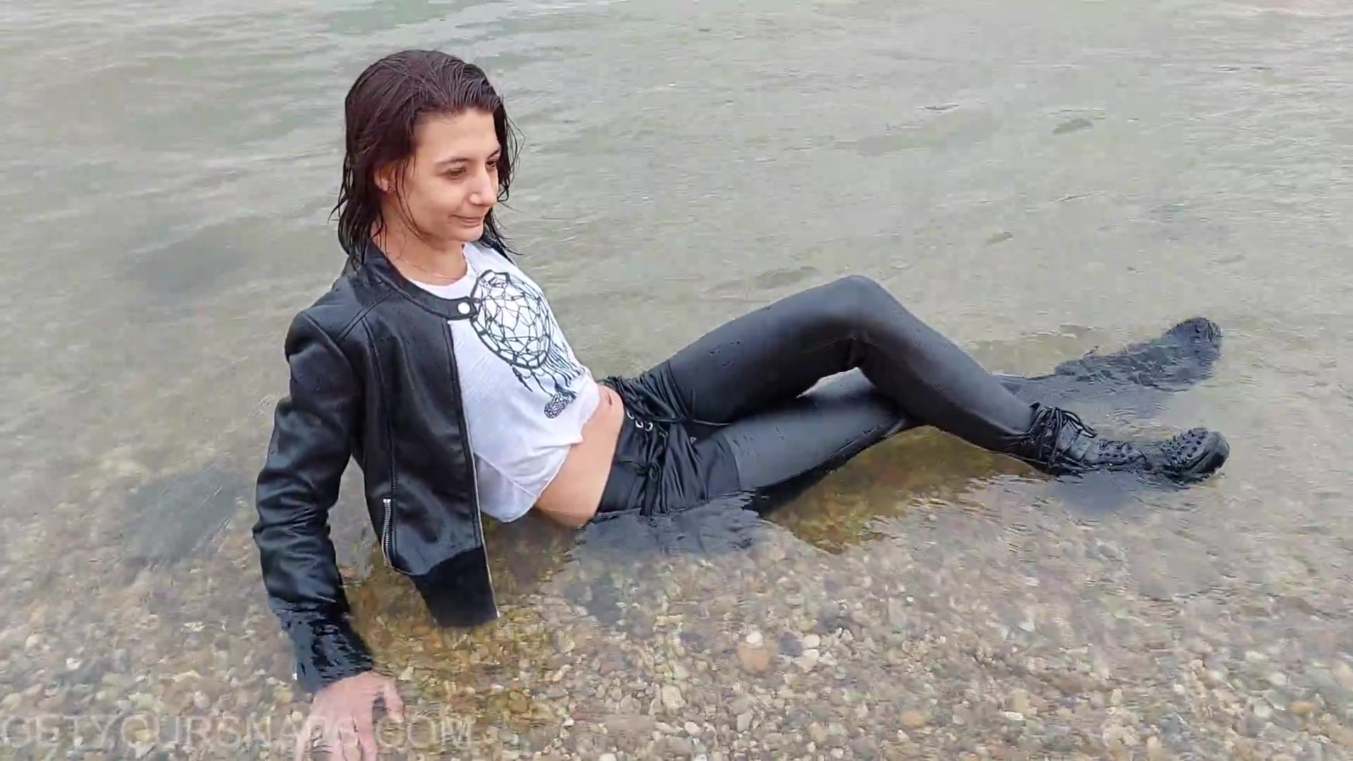 Mina poses in the river in a wet dress - frame at 7m8s