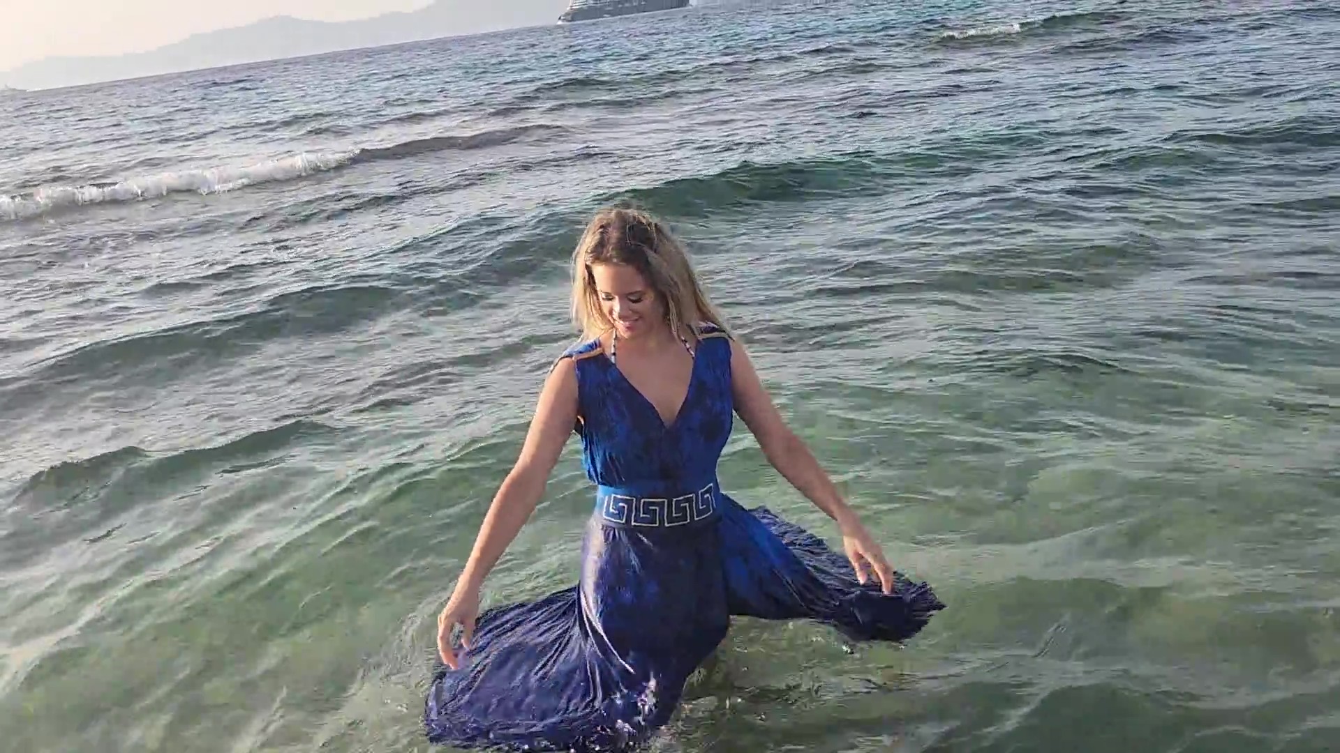 Bella goes swimming in the sea in her blue dress - Image 4