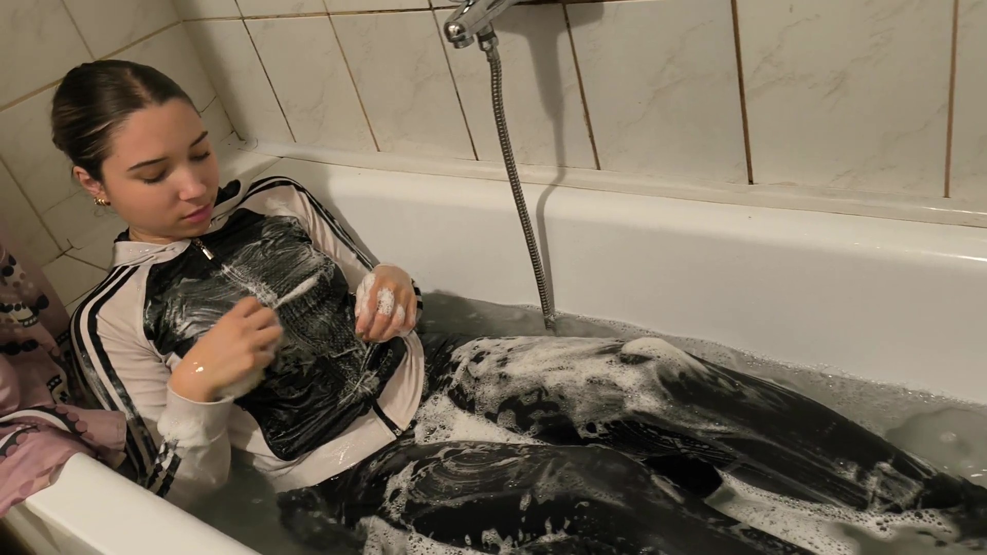 Ellie takes a bath in shiny leggings and a B&W Adidas sweater - Image 3